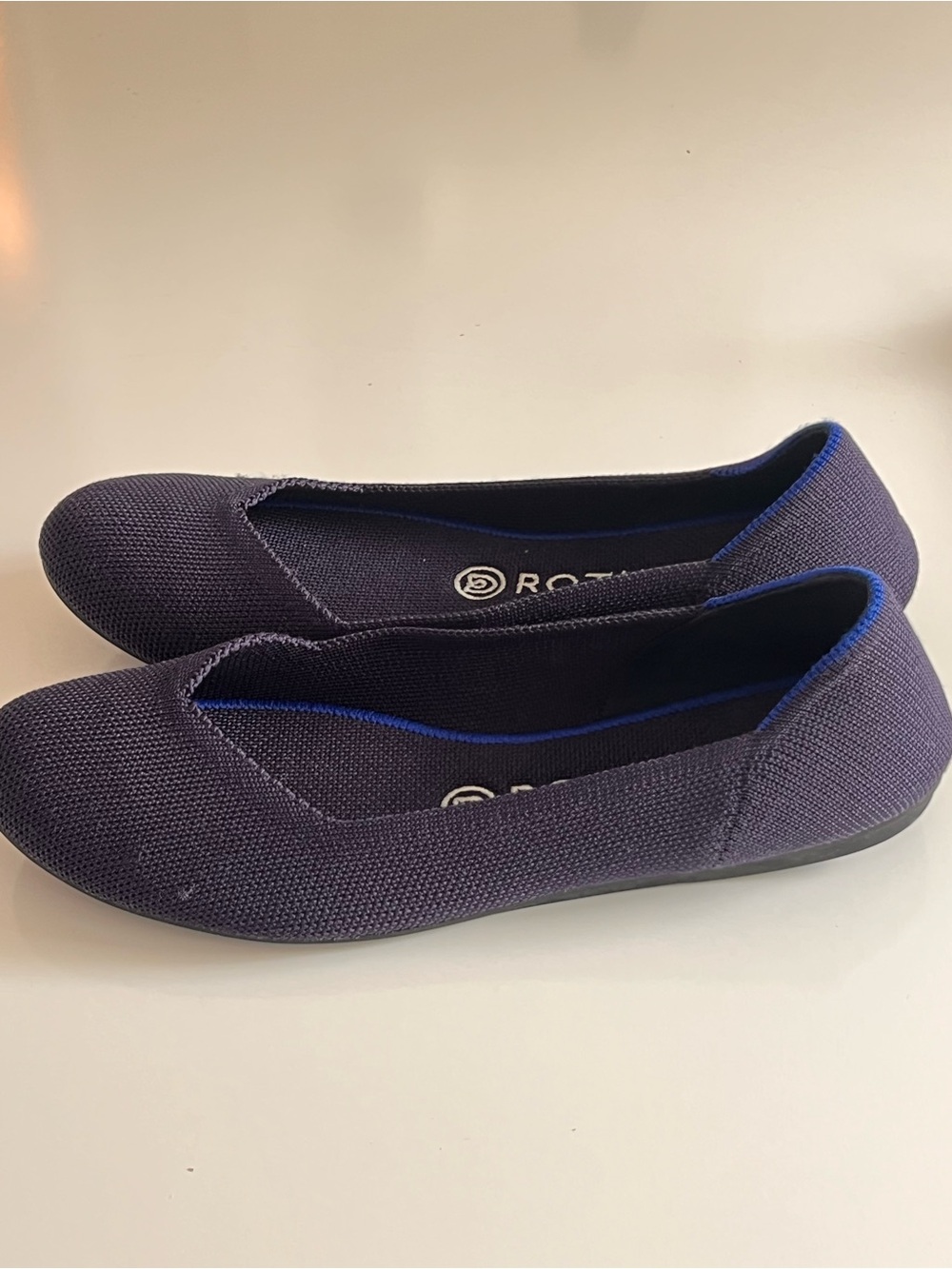 Rothy's navy blue round-toe knit flat shoes featuring a distinctive bright blue - Picture 7 of 12